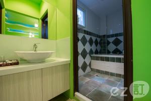 baño verde con lavabo y ducha en Red Sun en Checheng