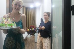 een vrouw die een taart vasthoudt voor een spiegel bij An Bang Beach Dolphin Homestay in Hội An +31 foto's