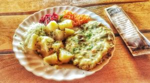 a white plate of food on a wooden table at Pas Medžiotoją Motelis in Kryžkalnis +12 photos