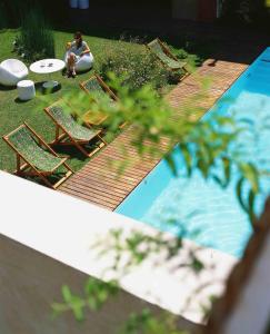 uma mulher sentada em cadeiras ao lado de uma piscina em Home Hotel em Buenos Aires