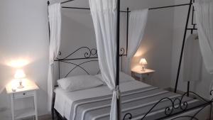 a bedroom with a black canopy bed with two lamps at Apartment Ostiense Piramide Station in Rome