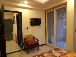 a room with a chair and a tv on the wall at Lila's Abode - Homestay in Jaipur