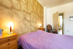 Dormitorio con cama morada y tocador con 2 velas en Appartamento 160 mq en Milán