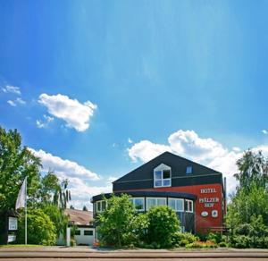 um edifício vermelho com um telhado preto em Hotel Pfälzer Hof em Braunschweig