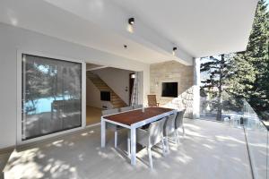 a dining room with a table and chairs on a balcony at Chiponsky One - 5 star beachfront property in Bol