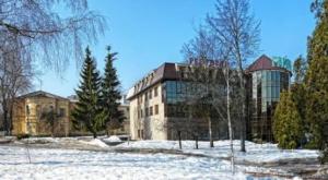 a large building in a field with snow and trees at Hotel Complex Gayki in Zhytomyr