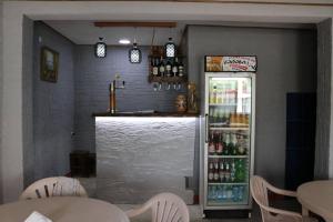 a bar in a restaurant with a refrigerator filled with drinks at Cactus Hotel in Kobuleti