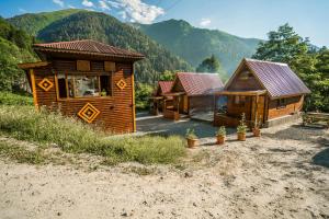 a group of wooden cabins with mountains in the background at Ayder Şelale Dağ Evleri in Ayder Yaylasi