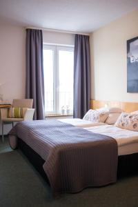 - une chambre avec 2 lits et une grande fenêtre dans l'établissement Hotel Restaurant Am Kellhof, à Singen