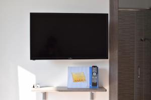 a flat screen tv on a wall with a remote control at Lvresidence Roccelletta in Catanzaro Lido