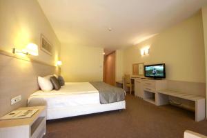 Habitación de hotel con cama y TV de pantalla plana. en Savoy Hotel, en Timisoara
