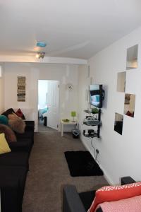 a living room with a couch and a tv at Sea-Esta in Weymouth