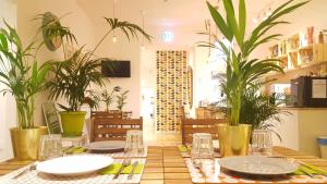 a dining room with a table with plates and plants at Napoli Tree - Lungomare in Naples