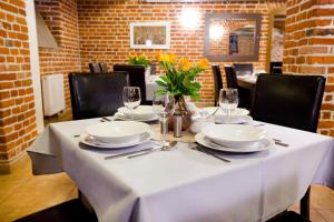 a white table with plates and glasses on it at Pokoje U Filipa in Krakow