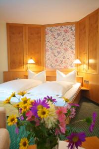 イッラーティッセンにあるホテル & レストラン ドーンバイバー ホフのホテルルーム ベッド2台、フロアに花を飾った客室です。
