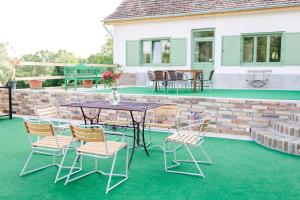 a patio with a table and chairs on a lawn at Maison BOGArT in Alsobogát +85 photos