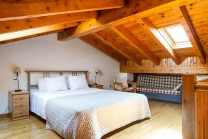 1 dormitorio con cama grande y techo de madera en la Cabana dels Isards, en Alp