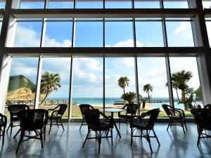 a room with a table and chairs and a beach at Tanegashima Iwasaki Hotel in Minamitane