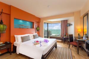 芭達雅中心的住宿－The Bayview Hotel Pattaya，一间卧室配有一张带橙色墙壁的大床
