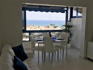 Un comedor con mesa y sillas y el océano. en Bello Horizonte, en San Agustín