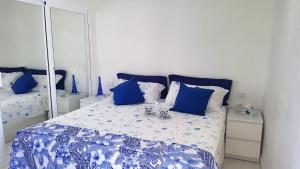 Un dormitorio con una cama azul y blanca con espejo en Bello Horizonte, en San Agustín 19 fotos más