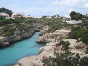 a group of people standing on a beach next to a river at Ses Sivines 25 in Ciutadella
