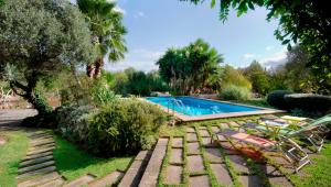 una piscina en un patio con sillas y árboles en La Torre, en Pollensa
