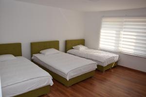 two twin beds in a room with a window at A&S Villa Sarajevo in Hadžići