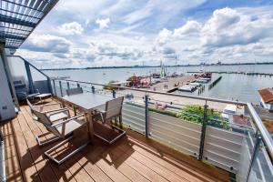 - un balcon sur un bateau avec une table et des chaises dans l'établissement Haus Putbus - Ferienwohnung 7 "Southwest beach", à Altefähr