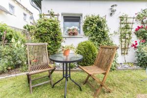 two chairs and a table in a yard at Ferienwohnungen in ruhiger Ortsran in Lauterbach