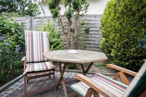 einen Holztisch und zwei Stühle auf einer Terrasse in der Unterkunft Ferienwohnungen in ruhiger Ortsran in Lauterbach