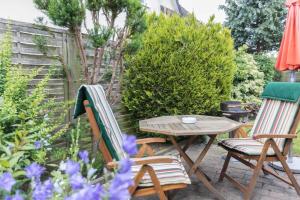 eine Terrasse mit 2 Stühlen und einem Tisch im Garten in der Unterkunft Ferienwohnungen in ruhiger Ortsran in Lauterbach