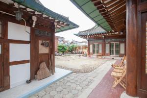 a courtyard of an asian building with a wooden door at The Hanok in Jeonju