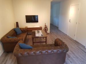 a living room with two couches and a television at Bólstaðarhlíð Guesthouse in Bólstaðarhlíð