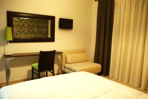 a bedroom with a bed and a desk and a chair at Doviros Hotel in Doirani