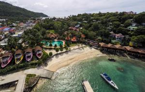 eine Luftaufnahme eines Strandes mit einem Boot im Wasser in der Unterkunft Marissa Hotel in Haad Rin