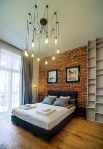 - une chambre avec un grand lit et un mur en briques dans l'établissement Swiety 7, à Poznań