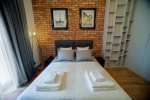 a bedroom with a large bed with a brick wall at Swiety 7 in Poznań