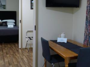Habitación con mesa y dormitorio con cama. en Watervale Retreat en Watervale
