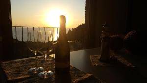 two wine glasses sitting on a table with the sunset at Tanca Piras - Emozioni a strapiombo sul Mare!!! in Nebida