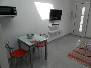een kamer met een tafel en stoelen en een televisie bij la pinède in Peymeinade