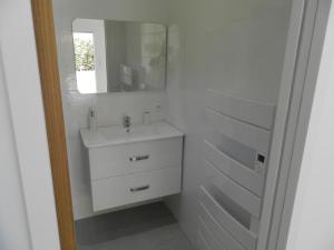 a white bathroom with a sink and a mirror at la pinède in Peymeinade