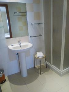 y baño con lavabo y ducha. en Hostal Restaurante Taracena, en Yunquera de Henares
