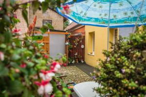 a house with an umbrella over a courtyard with flowers at Apartament CCH in Chełmno