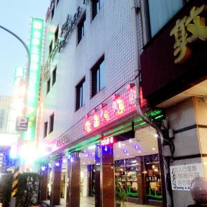 a building with neon signs on the side of a street at Guang Haw Hotel in Tainan