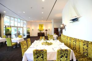 a dining room with white tables and yellow chairs at Hansa Apart-Hotel Regensburg in Regensburg