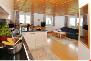 a kitchen and living room with a couch and a table at Haus Madrisella in Gaschurn