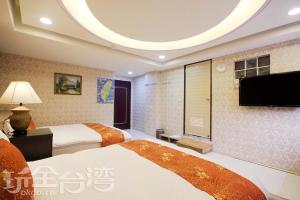 Habitación de hotel con 2 camas y TV de pantalla plana. en Good Sleep B&B en Ruifang