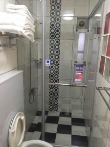 a bathroom with a glass shower with a toilet at Good Sleep B&B in Ruifang