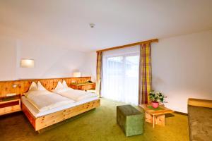 a bedroom with a bed and a large window at Hotel Mathiesn in Obergurgl
